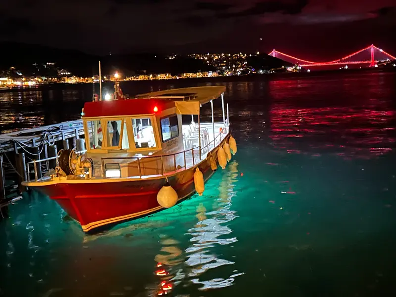Gece Boğaz kıyısında teknemiz ve arkasında ışıklı köprü